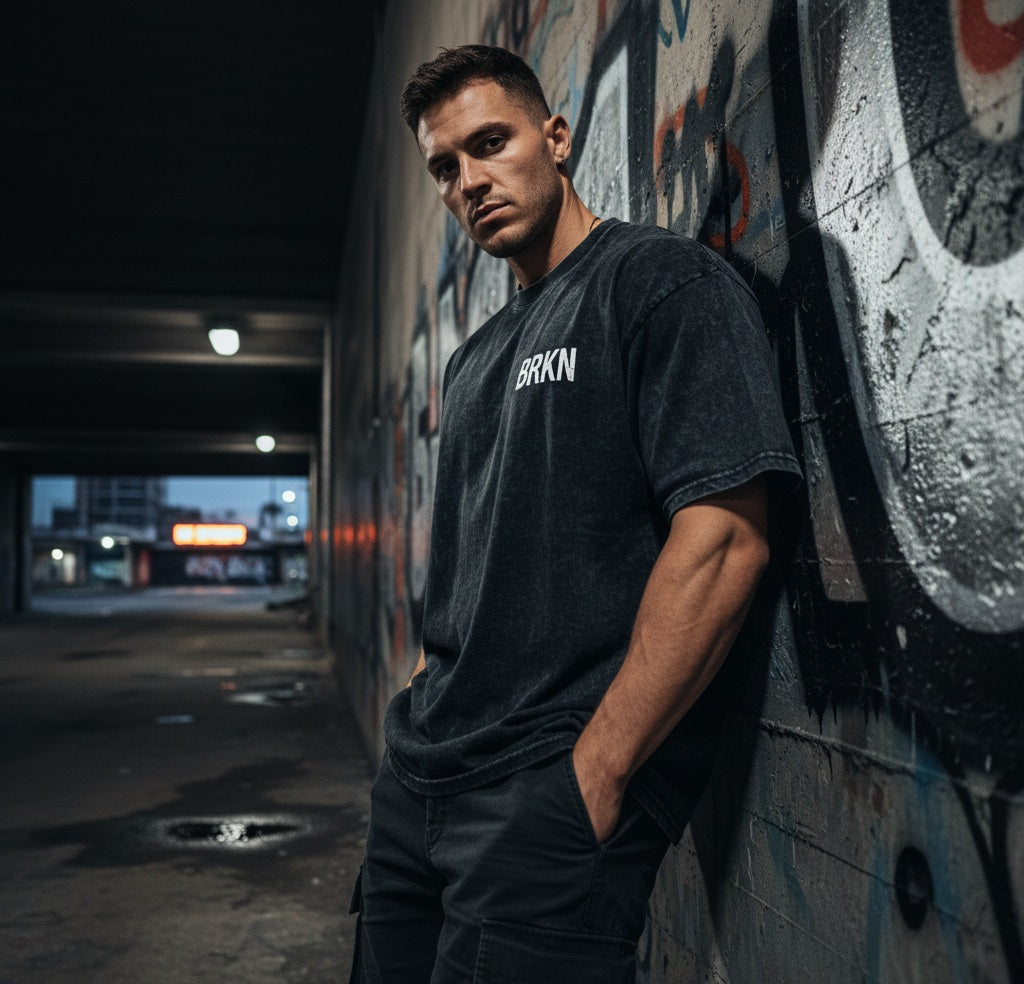 BRKN black oversized heavyweight tee worn against a graffiti wall